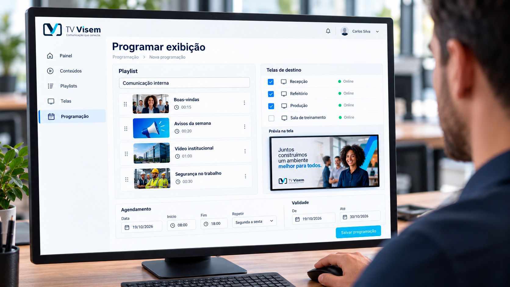 Gestora escolhendo no tablet as telas, os dias e os horários em que o conteúdo vai aparecer.